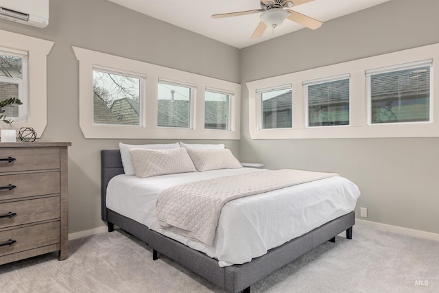 bedroom with an AC wall unit, baseboards, and light carpet