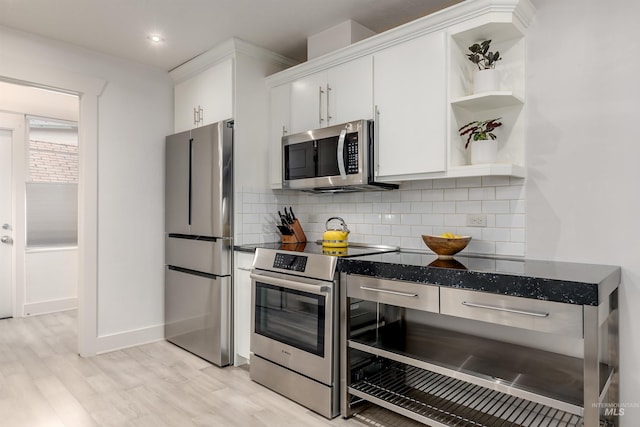 kitchen with light wood-style floors, stainless steel appliances, tasteful backsplash, and white cabinetry