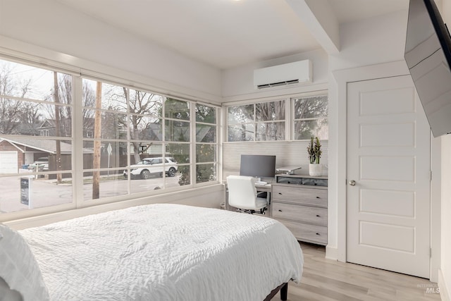 bedroom featuring multiple windows, wood finished floors, and a wall mounted AC