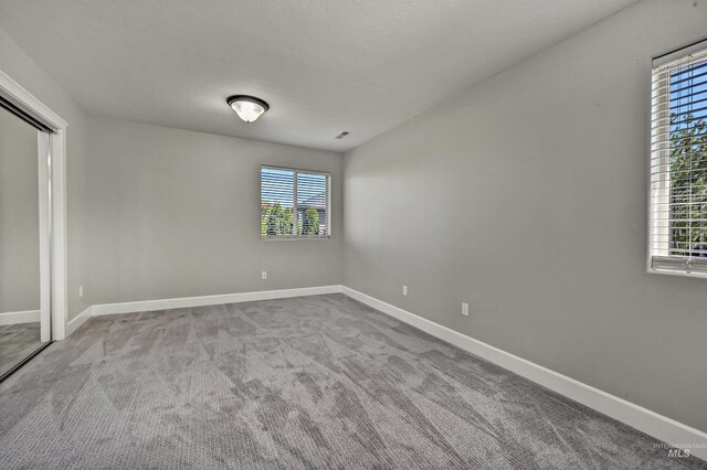 5278 N Cougar Flat Pl, Meridian, ID 83646 - unfurnished bedroom featuring multiple windows, a closet, baseboards, and carpet