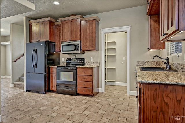 5278 N Cougar Flat Pl, Meridian, ID 83646 - kitchen with a sink, a textured ceiling, light stone counters, black appliances, and baseboards