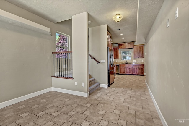 5278 N Cougar Flat Pl, Meridian, ID 83646 - interior space featuring a textured ceiling, baseboards, a sink, and stairway