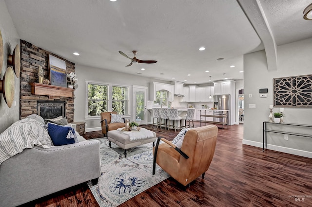 5278 N Cougar Flat Pl, Meridian, ID 83646 - living room featuring a ceiling fan, dark wood-style flooring, baseboards, and a fireplace