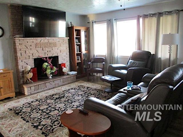 living room featuring ceiling fan and a textured ceiling