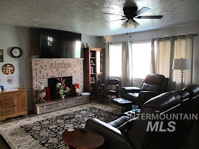 living room with ceiling fan and a textured ceiling