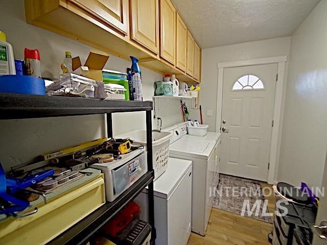 washroom with separate washer and dryer, a textured ceiling, and light hardwood / wood-style flooring