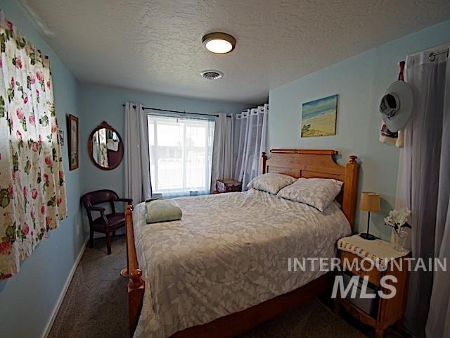 bedroom with carpet floors and a textured ceiling