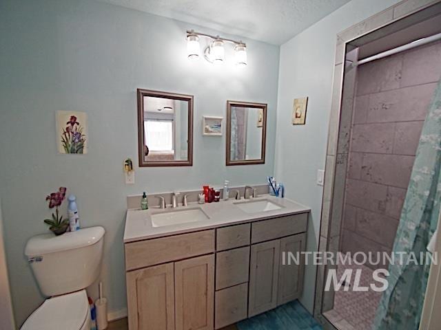 bathroom with vanity, toilet, a textured ceiling, and a shower with curtain