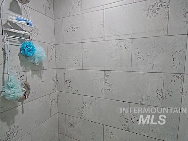 interior details featuring a tile shower