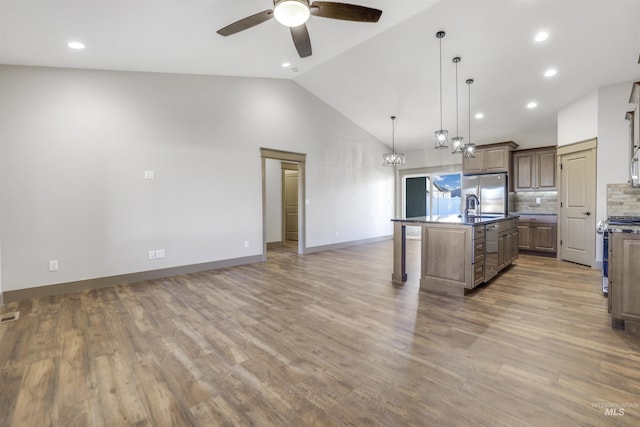 1487 Zephlyn St, Twin Falls, ID 83301 - kitchen featuring appliances with stainless steel finishes, tasteful backsplash, hanging light fixtures, hardwood / wood-style flooring, and a kitchen island with sink