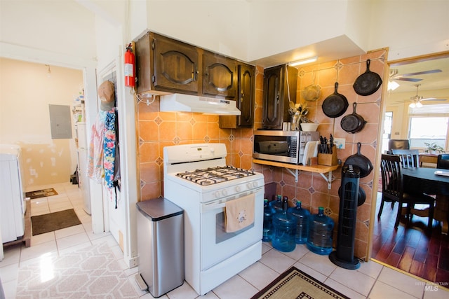 599 S Ada St, Glenns Ferry, ID 83623 - kitchen featuring white gas range oven, under cabinet range hood, stainless steel microwave, electric panel, and a ceiling fan