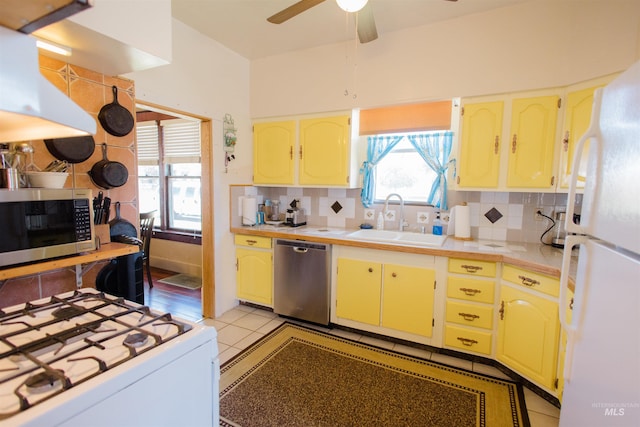 599 S Ada St, Glenns Ferry, ID 83623 - kitchen with appliances with stainless steel finishes, a sink, under cabinet range hood, ceiling fan, and decorative backsplash