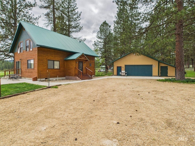 19 Hack Ln, Idaho City, ID 83631 - view of front of house with a garage, an outbuilding, metal roof, and entry steps