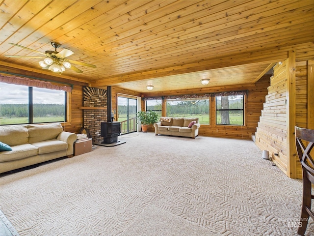 19 Hack Ln, Idaho City, ID 83631 - carpeted living room with a wood stove, wood walls, wooden ceiling, and ceiling fan