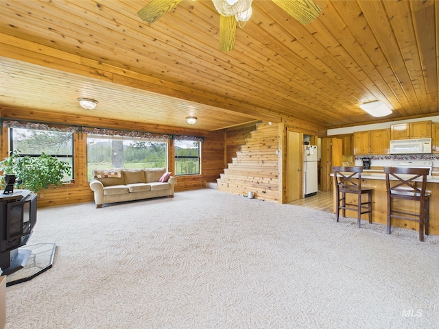 19 Hack Ln, Idaho City, ID 83631 - living room with wooden walls, a wood stove, light carpet, healthy amount of natural light, and wooden ceiling