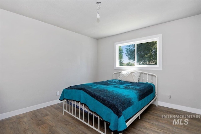 bedroom with dark wood-type flooring