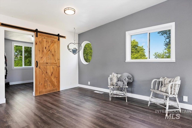 unfurnished room featuring dark hardwood / wood-style floors and a barn door