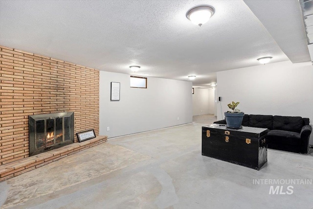 living room featuring a textured ceiling, a fireplace, and concrete floors