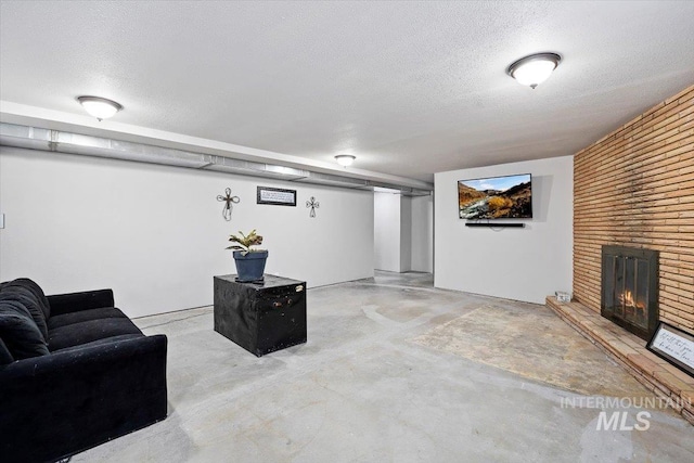 living room featuring a textured ceiling and a fireplace