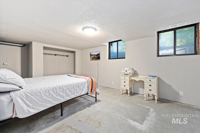 bedroom featuring concrete flooring and a textured ceiling