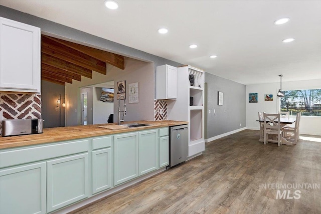 kitchen featuring wood-type flooring, stainless steel dishwasher, butcher block counters, and decorative light fixtures