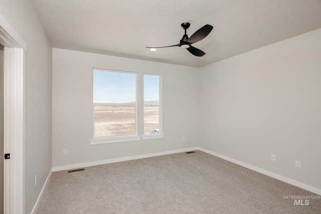 unfurnished room with ceiling fan and carpet