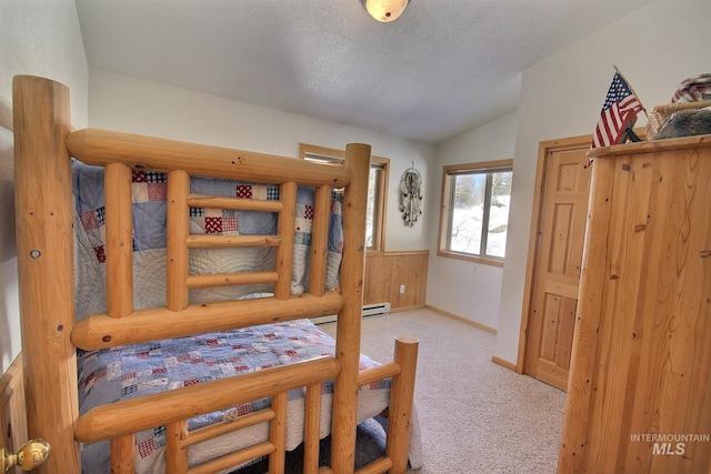 carpeted bedroom featuring baseboard heating, vaulted ceiling, and a textured ceiling