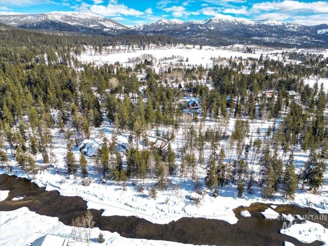 14187 Hancock Rd, Mccall, ID 83638 - snowy aerial view featuring a wooded view and a mountain view