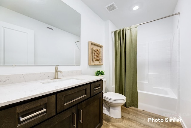 bathroom featuring shower / bath combo, wood finished floors, vanity, toilet, and visible vents