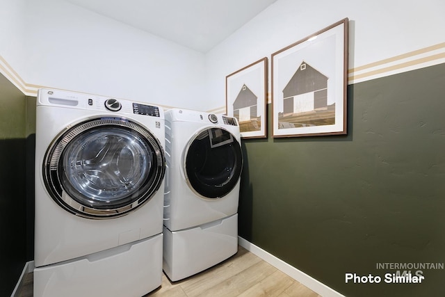 laundry room featuring laundry area, baseboards, washing machine and dryer, and light wood-type flooring