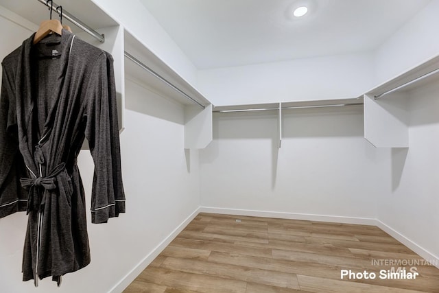 walk in closet with wood finished floors