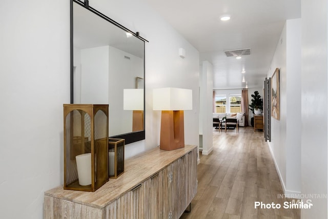 hall featuring recessed lighting, visible vents, light wood-type flooring, and baseboards