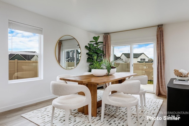 dining area featuring light wood finished floors and baseboards