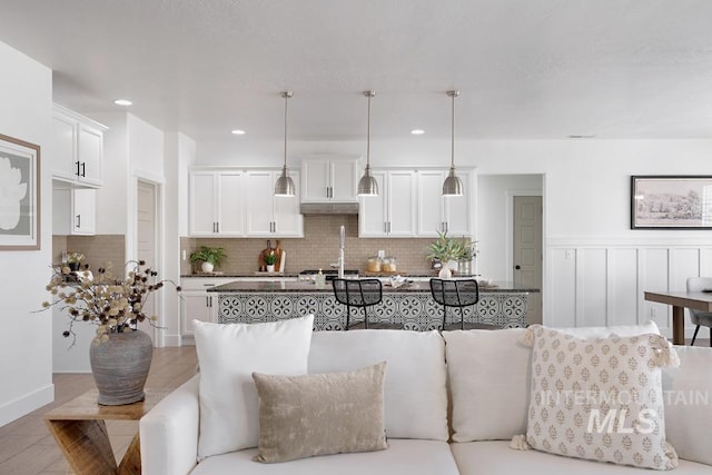 living area with recessed lighting and wainscoting