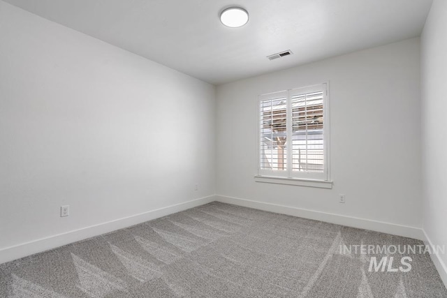 empty room with baseboards and carpet