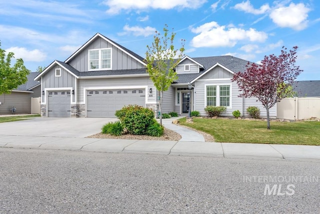 view of front of property featuring board and batten siding, driveway, a garage, and stone siding
