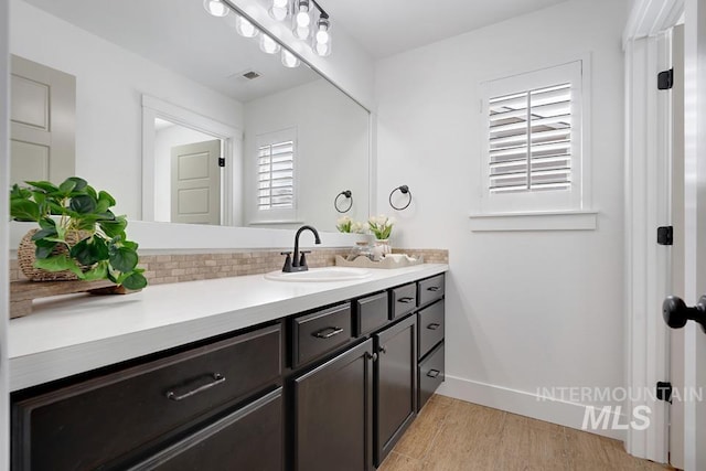 bathroom featuring vanity, wood finished floors, and baseboards