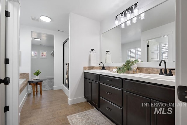 bathroom with plenty of natural light, wood finished floors, and a shower stall