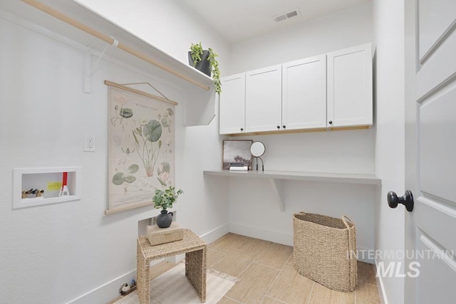 laundry area featuring cabinet space, washer hookup, baseboards, and light wood-style floors