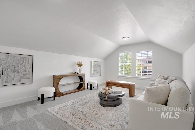 living area with carpet flooring, lofted ceiling, and baseboards