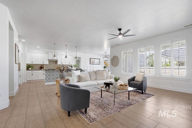 living area with ceiling fan, baseboards, and recessed lighting