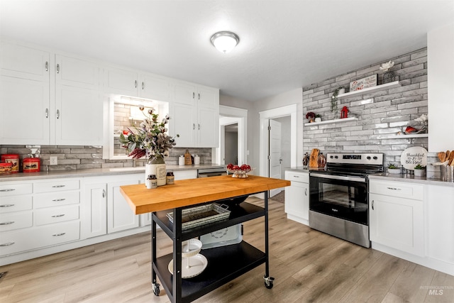 kitchen featuring stainless steel range with electric stovetop, light hardwood / wood-style flooring, tasteful backsplash, and white cabinetry