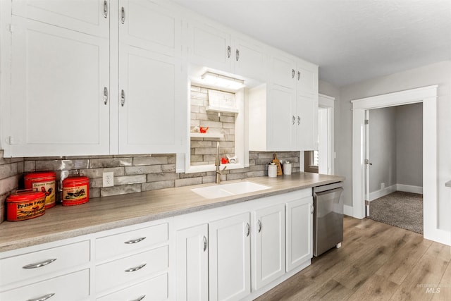 kitchen with light hardwood / wood-style floors, sink, white cabinetry, and stainless steel dishwasher