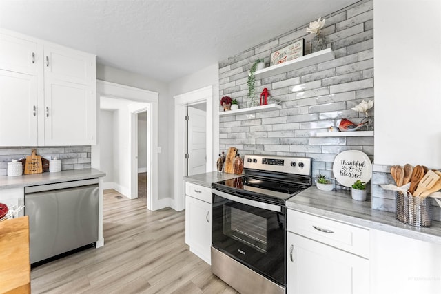 kitchen featuring backsplash, appliances with stainless steel finishes, light wood-type flooring, and white cabinetry