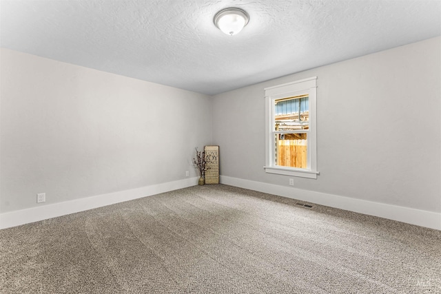 unfurnished room with a textured ceiling and carpet flooring