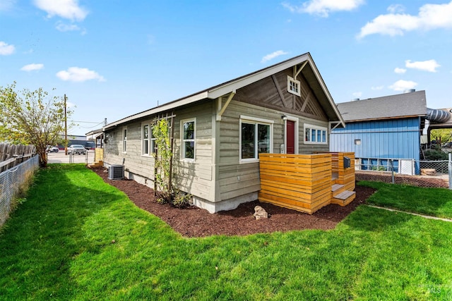 rear view of property featuring cooling unit and a yard