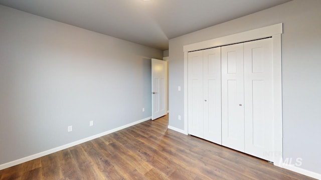 unfurnished bedroom featuring dark wood-type flooring and a closet