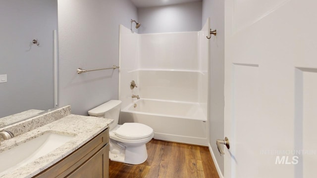 full bathroom featuring wood-type flooring, bathtub / shower combination, vanity, and toilet