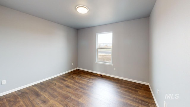 spare room featuring dark hardwood / wood-style floors