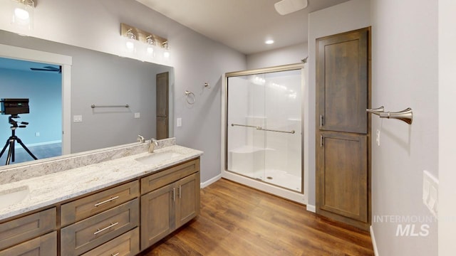 bathroom featuring an enclosed shower, vanity, and wood-type flooring